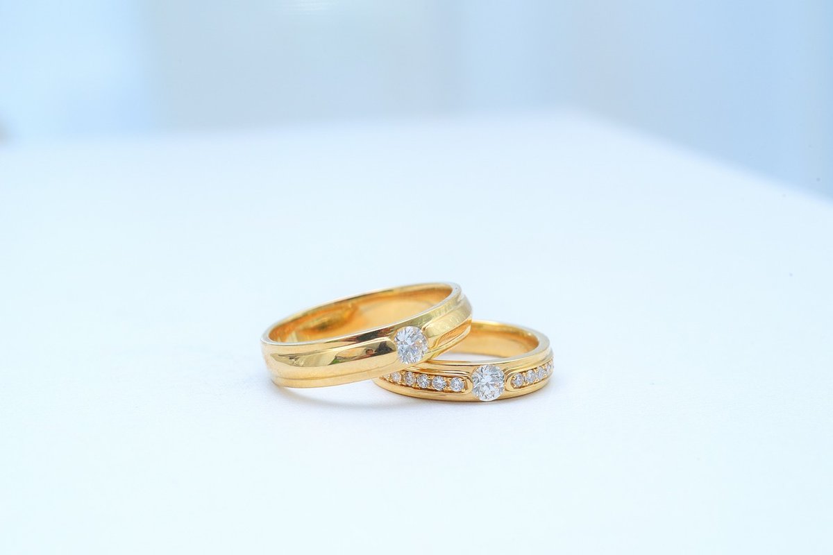 Two gold wedding rings resting on natural rock, symbolizing the union for a thailand marriage visa application